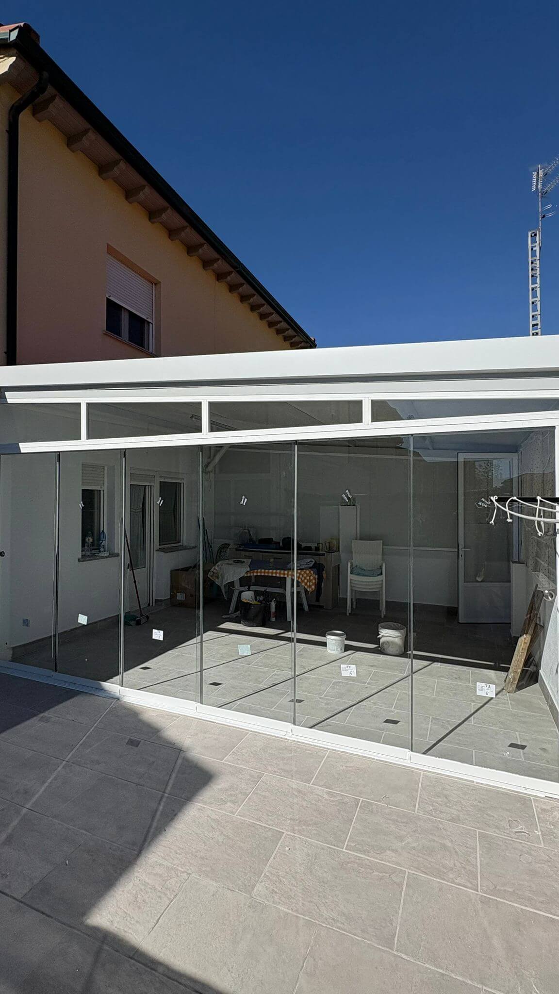 Balcón cerrado con cortina corredera y toldo